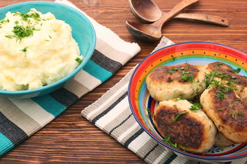 Fried savory tuna patties with potato in the bowl on wooden table