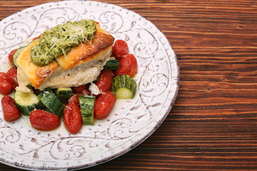 Tasty baked chicken breasts which basil pesto sauce, tomatoes, and cheese. Healthy eating concept.