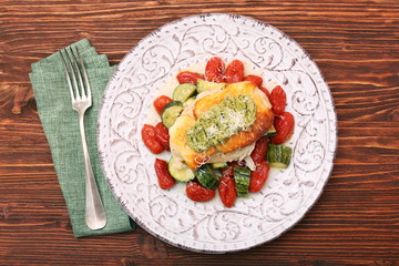 Tasty baked chicken breasts which basil pesto sauce, tomatoes, and cheese. Healthy eating concept.