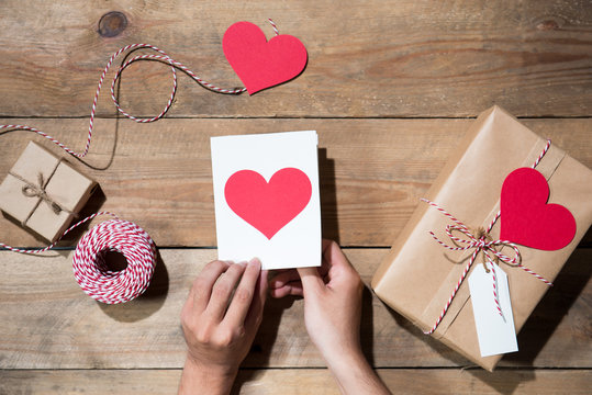 Valentine's decorated gift box over wooden background. View from