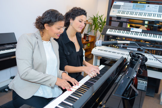 Two women playing keyboard