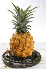 Ripe juicy fresh baby pineapple on black stone