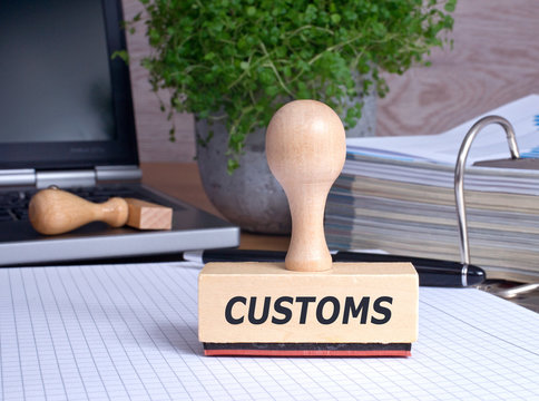 Customs Stamp on desk in the Office with binder and laptop