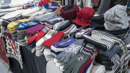 Group of handmade colorful knitted socks, mittens, gloves and hats in the market.