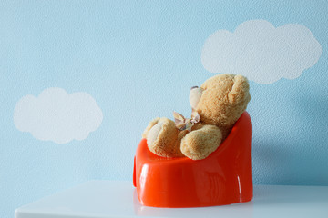 Teddy bear sitting on the potty