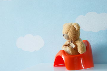 Teddy bear sitting on the potty