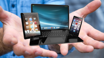Businessman holding laptop phone and tablet in his hand 3D rende