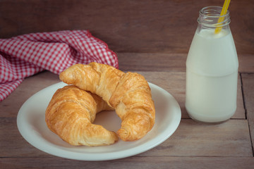 Croissants on plate with milk bottle