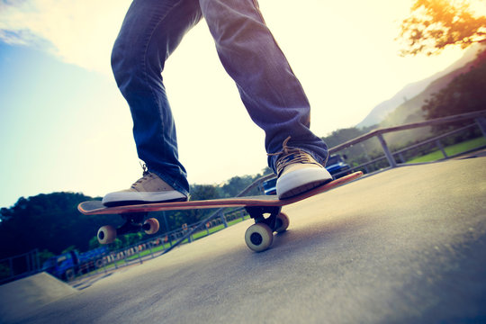 young skateboarder legs skateboarding at skatepark