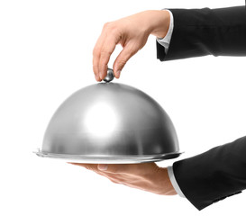 Hands of waiter holding metal tray with cover on white background