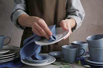 Closeup of female hands cleaning saucer