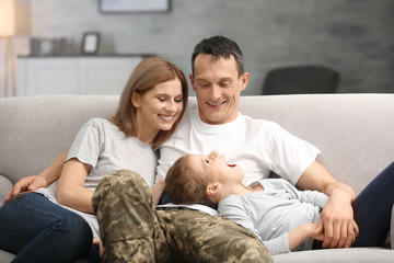 Military father with his family on sofa at home
