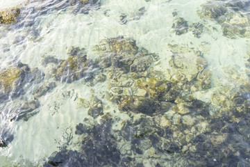 Rocks by the sea with waves of the Mediterranean sea next to the