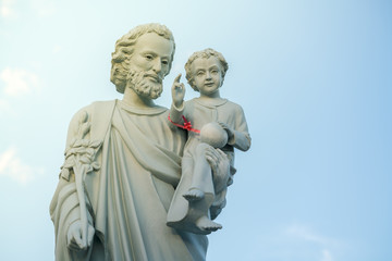 classical statue of Saint Joseph with child Jesus on blue sky.
Joseph is a figure in the Gospels,...