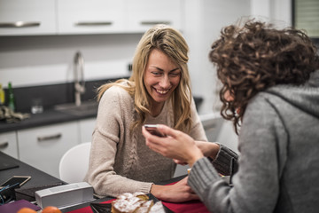due amiche si divertono e usano uno smartphone