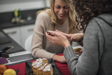 due amiche si divertono e usano uno smartphone