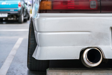 Car exhaust pipe muffler rejecting carbon dioxide.
exhaust pipe of a white car with copy space