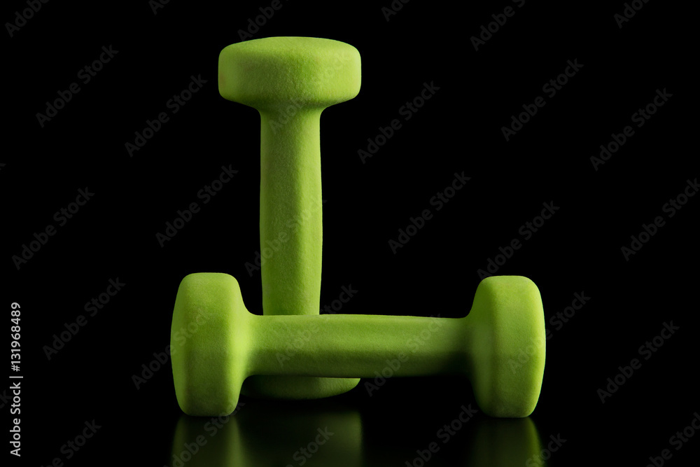 Wall mural green dumbbells on black background