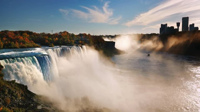 Niagara River at sunset near Niagara Falls. The sun's rays illuminate the waterfall, the ship sails on the river