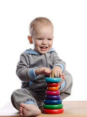 Obraz premium cute boy playing with color pyramid toy
