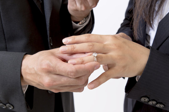 恋人に婚約指輪をはめる手元のアップ