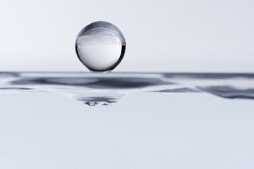 Macro of a water drop, in the millisecond before splashing in to the water. Both views from above and under the water.