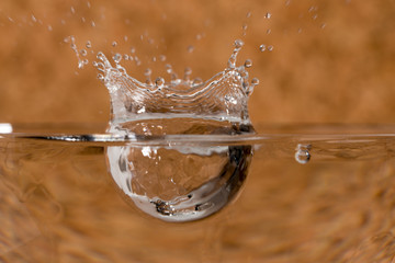 Lateral macro view of the outline when a water drop hit the surface of the water. Both views from...