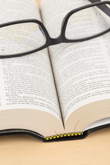 Glasses on holy bible page concept theology study