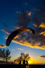Silhouette skydiver parachutist training at sunset