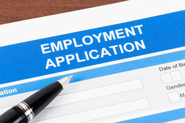 Employment application form with pen; document is mock-up