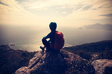 successful hiker on seaside mountain peak rock