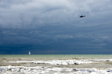Aufgewühlte Ostsee mit Segelboot bei düsterem Wetter