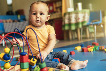 Happy baby playing with toy blocks.