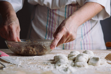 Front view of woman's hands making meat stuffing for dumplings.