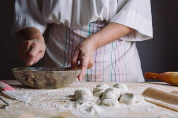 Front view of woman's hands making meat stuffing for dumplings.