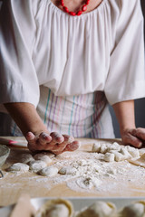 Obraz na płótnie Canvas Front view of woman's hands making dough for meat dumplings.