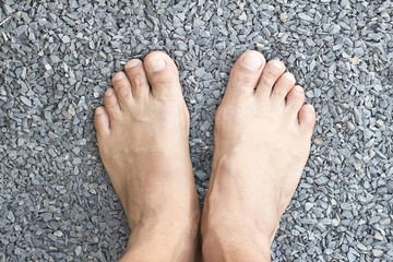 man bare feet in rocks