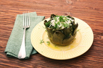 Baked artichoke with cheese on wooden background