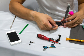 Repairing mobile phones are changing mobile phone screen to the customer at his shop. Mobile shop repair and service.