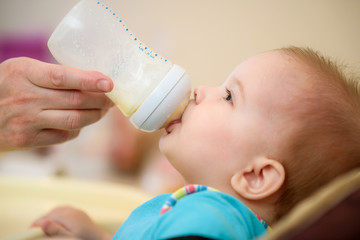 Mother feeds baby from a bottle of milk