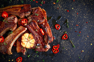 Roasted lamb cutlets ribs with garlic and herbs on stone background