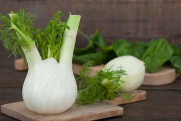 Fresh fennel and spinach on wooden boards