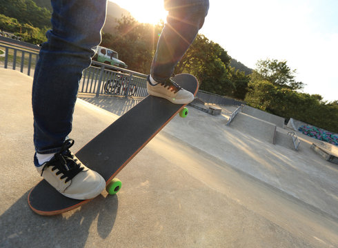 people legs practice skateboarding at skatepark