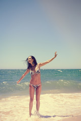 Fototapeta na wymiar Playful joyful woman with perfect body relaxing feeling free, having fun on tropical beach vacation