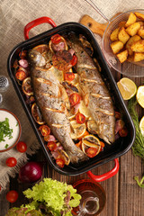 Fototapeta na wymiar Baked fish with vegetables and potatoes in pan