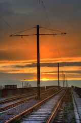 Fototapeta na wymiar Old rusty tramway on a bridge on a sunset background