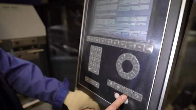The worker presses buttons of the panel of the machine tool with numerical programmed control. The engineer configures a program for operation of the machine.