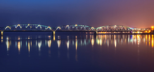 Fototapeta premium Panoramic view of road bridge over Vistula river in the night. Torun, Poland.