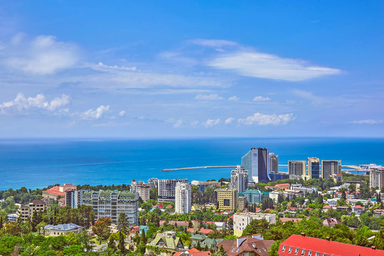 Blue Coast Of Black Sea In Sochi With Houses Under Summer Cloudy Sky