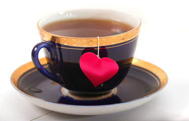 Cup with a shadow in the form of heart and a heart on a thread